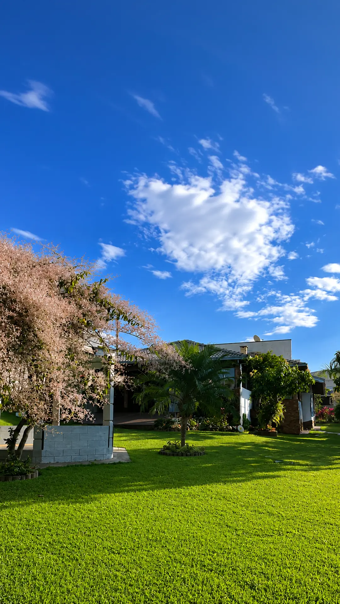 Fachada da casa com garagem coberta e jardim florido