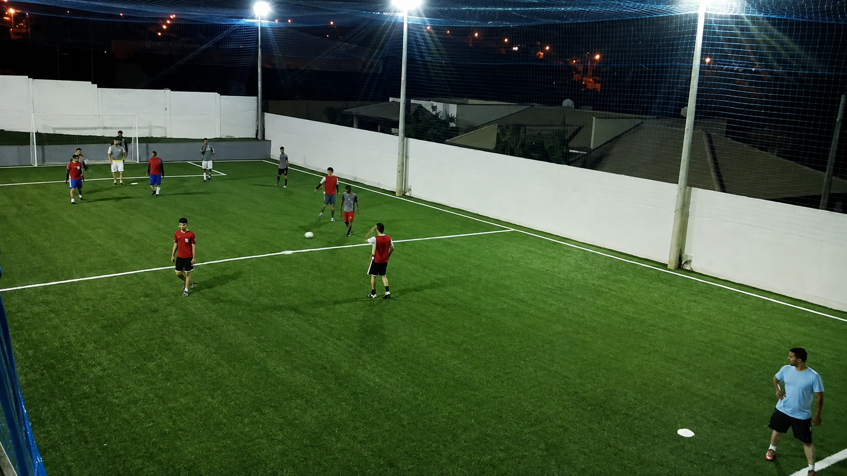 Jogo noturno no campo de futebol society da propriedade
